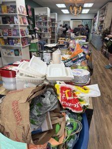 Photograph of a bookstore with long tables covered with food and bags.